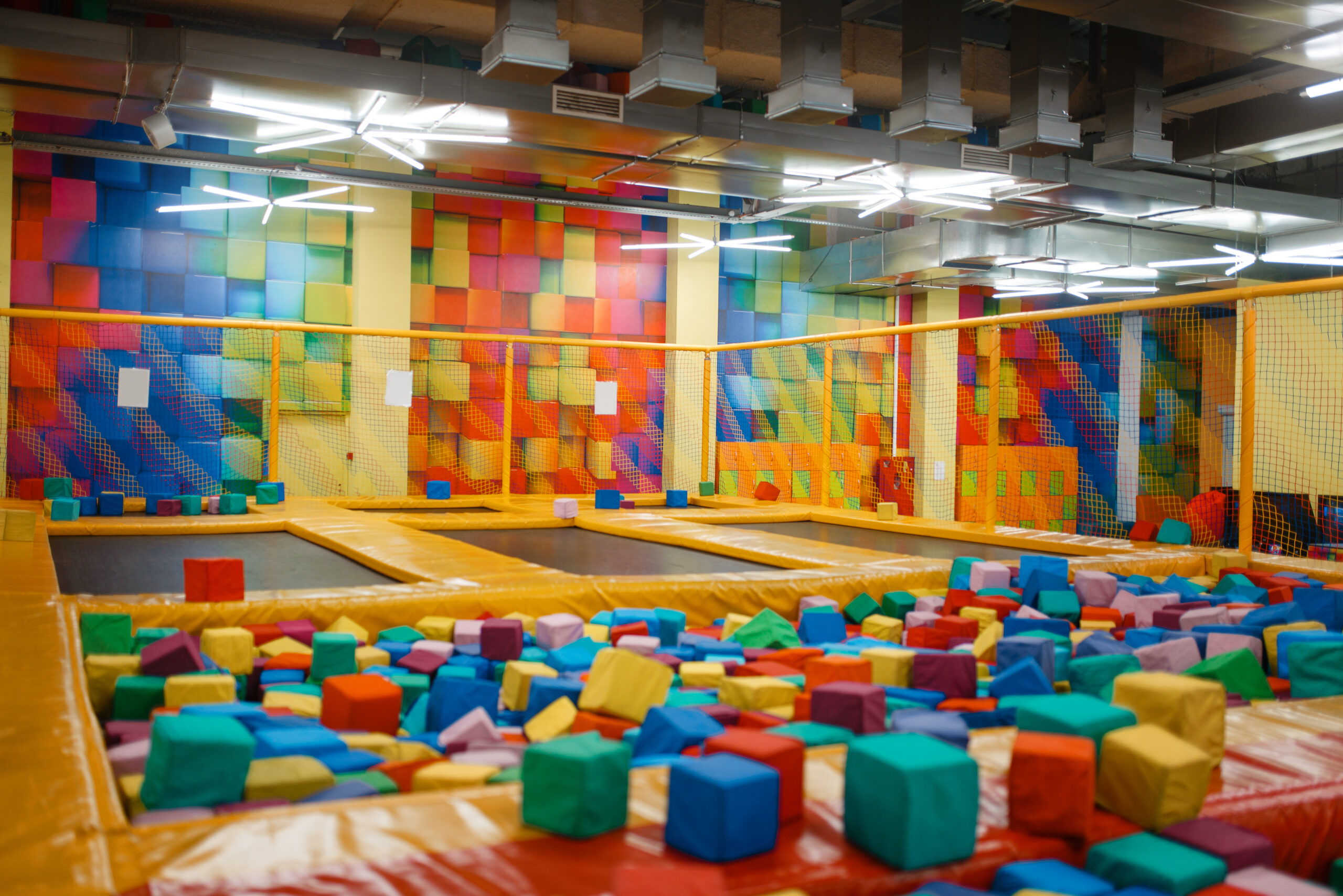 Kids trampoline and soft cubes on playground in entertainment center, nobody. Play area for children indoors, playroom