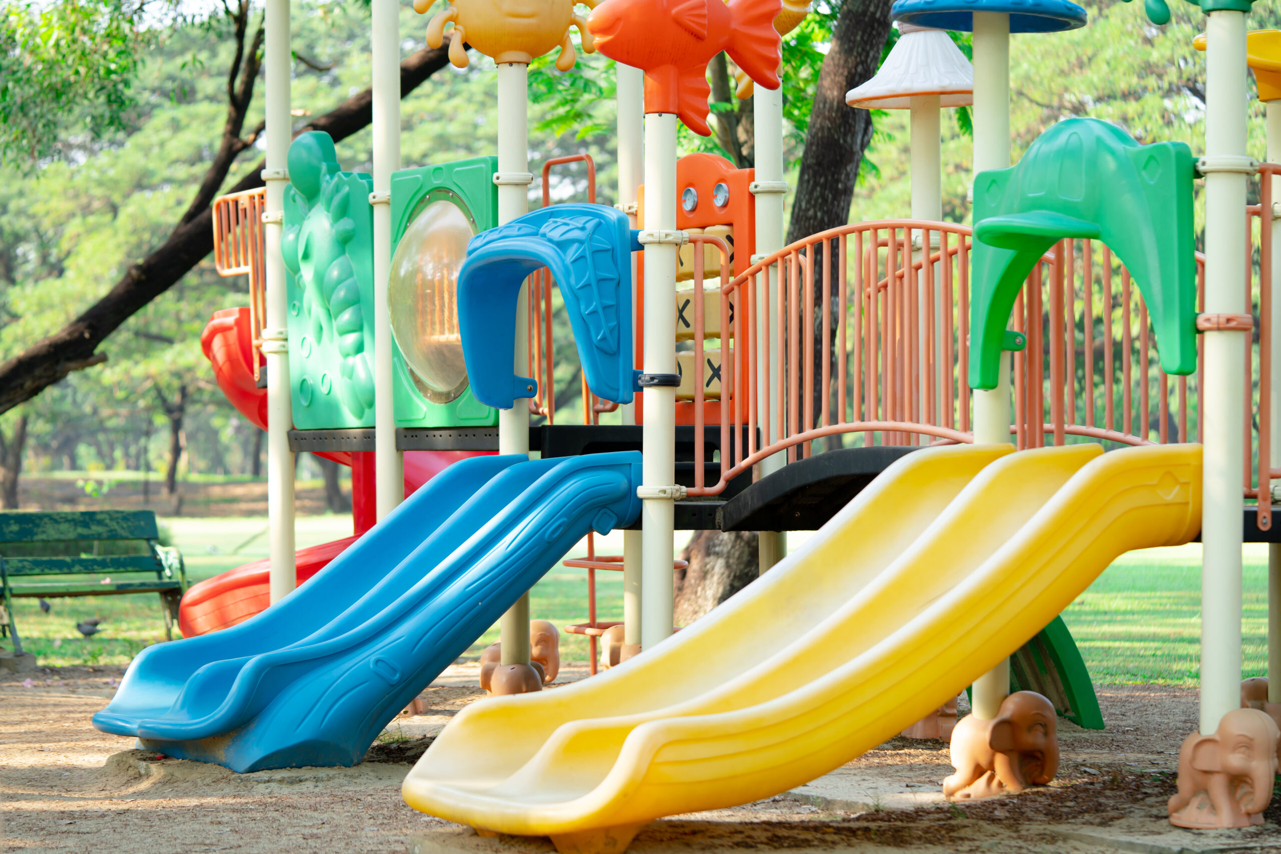 Playground for kid children having fun with colorful slide at yard activities in public park.